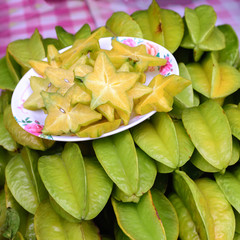 Fototapeta premium Dish of sliced star apple on pile.