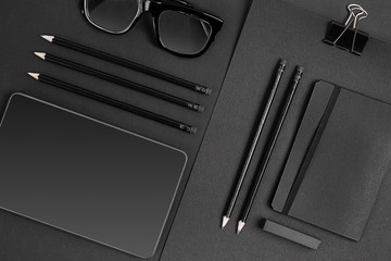 Blank notepad with clips, pens and glasses flat lay.
