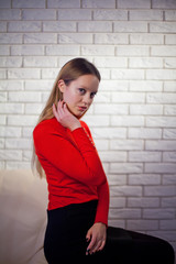 Young woman in red blouse next to brick wall Stylish fashion mod