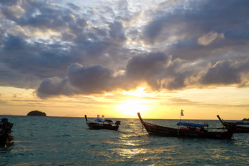 Traditional thai fishing boats at sunrise beam on beach