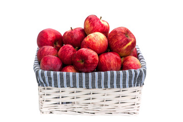 Basket with red apples in summer isolated on white background. Harvest of fresh fruits in the autumn. Delicious apples from the farm for a healthy diet food