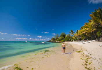 Man walking and relaxing on white sand tropical beach