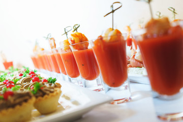 Seafood appetizer of shrimp and tomato sauce in a glass on a table.