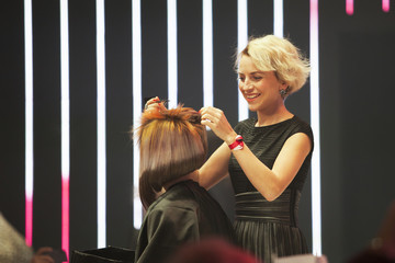 Professional hairdresser making stylish haircut on a stage