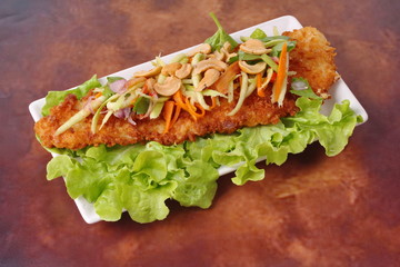 Spicy deep-fried Dolly's fish salad with roll green mango.