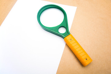 green loupe on a white sheet of paper. Search symbol.