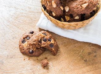 Chocolate chip cookies on napkin on wooden table.