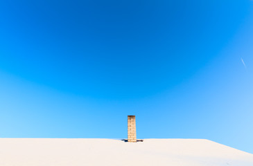 Snowy roof agains blue sky.