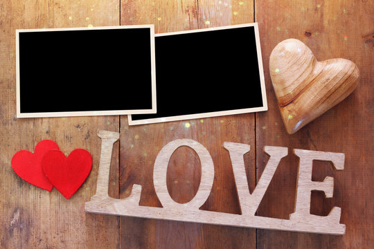 empty photo frames next word LOVE from wooden letters