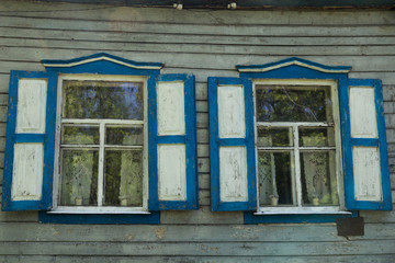 windows with shutters and curtains in an old wooden house.