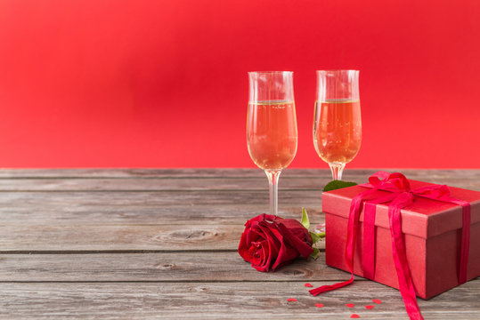 champagne glasses, red gift box and red roses