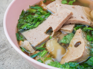 close up ekaehla one bowl put pork of meatballs, pork slices, coriander in a bowl of pink