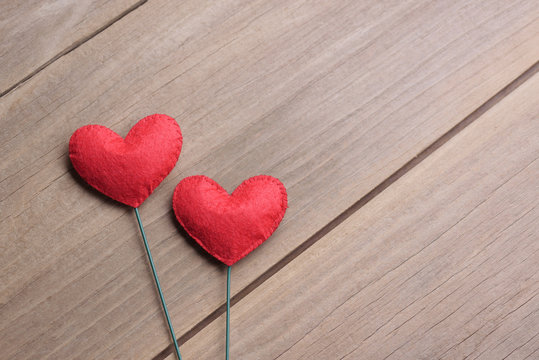 Valentines day concept of two heart shape decorations with old wood floor background.