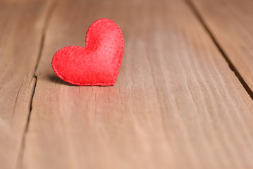 Valentines day concept of one heart shape decoration with old wood floor background.
