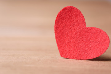 Valentines day concept of one red heart shape card with old wood floor background.