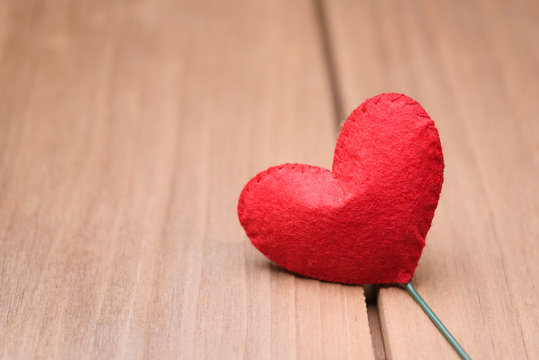 Valentines day concept of one heart shape decoration with old wood floor background.
