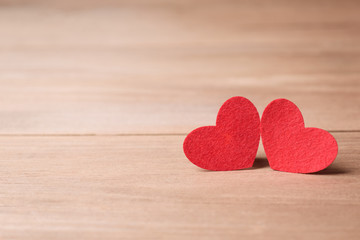 Valentines day concept of  two red heart shape cards with old wood floor background.