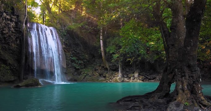 Clear waterfall flowing down turquoise clean river surrounded by jungle trees. Perfect place for relaxation in wild nature. Rainforest full of green plants. Summer time in remote forest 