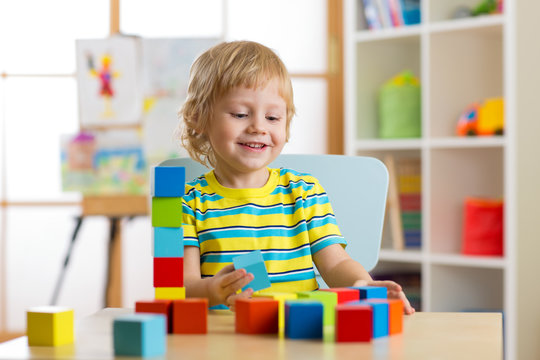 kid boy playing with block toys in day care center