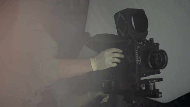 Man in gloves photographs on a retro camera close-up