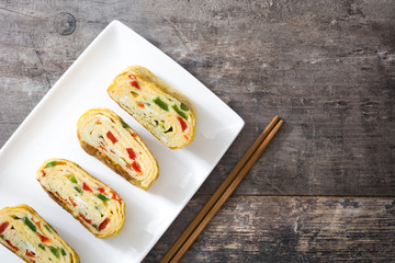 Traditional tamagoyaki Japanese omelette on wooden background