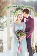 The groom embraces the bride. Winter wedding.