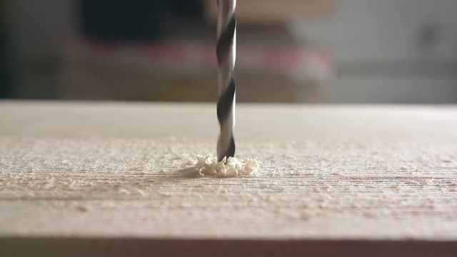 Close up of drill bit boring into wood 4K