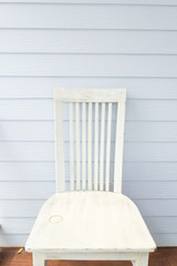 Fototapeta na wymiar White chair with blue plank wall