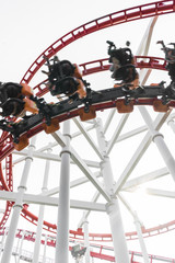 Roller coaster in the amusement park with people in a motion blu