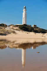 The lighthouse of the Cape of Trafalgar reflected in the water, in the coasts of the south of Spain