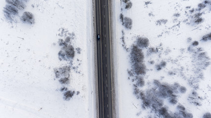 Top view at the winter asphalt highway with snow covered roadsides, Russia