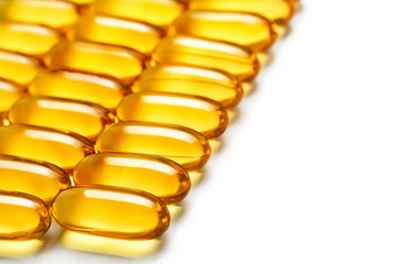 Laid out in rows of omega 3 capsules on white background. Close up, high resolution product.