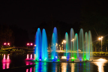 Fototapeta premium Fountain with backlight on pond in park