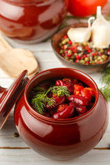 Stewed red beans with tomatoes and garlic in a ceramic pot. Vegetarian dish. Selective focus
