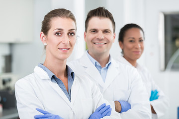 Fototapeta premium Group of scientists with gloves and gowns in laboratory