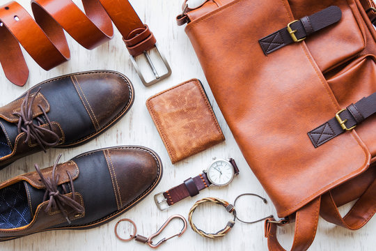 Men's casual outfits with leather accessories on white rustic wooden background, lifestyle traveler, beauty and fashion concept