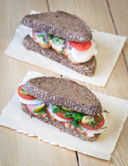 Fresh sandwich on a wooden table with a piece of burlap.