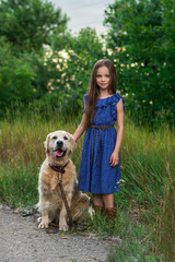 Little girl playing with her big dog outdoors in rural areas in