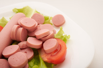 sausages with vegetables on a white background