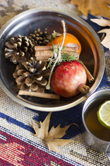 A nice autumn composition with leaves and some mix of autumn fruits together with cinnamon sticks.