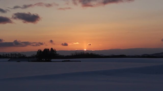 北海道　雪原に夕日が沈む瞬間
