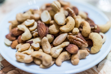Macro closeup of salted mixed nuts in plate