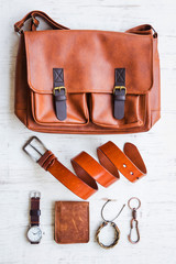 Men's casual outfits with leather accessories on white rustic wooden background, lifestyle traveler, beauty and fashion concept