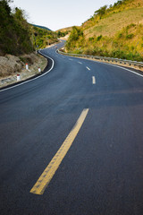 Obraz premium Infinity curved road with yellow line. Concept of adventure, travel, success...