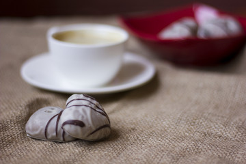 hot cup of coffee with couple of heart shaped chocolate cookies