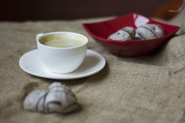 hot cup of coffee with couple of heart shaped chocolate cookies