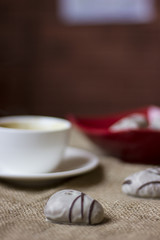 hot cup of coffee with couple of heart shaped chocolate cookies