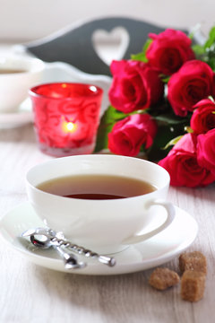 Romantic morning Tea for two with candles and bouquet of roses