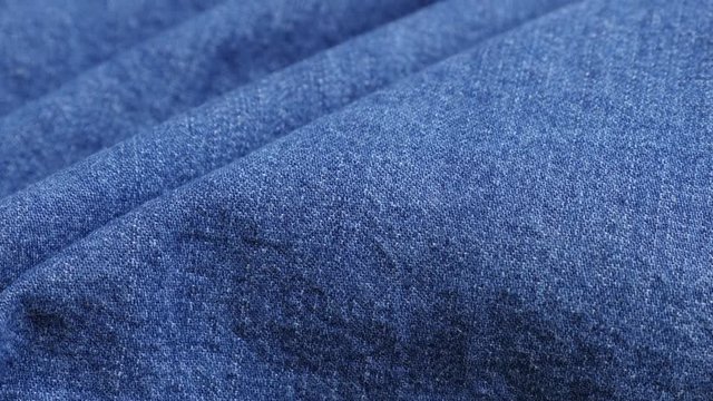 Classic blue denim surface gathers close-up 4K 2160p 30fps UltraHD tilting footage - High quality jeans texture details slow tilt shallow DOF 3840X2160 UHD video 