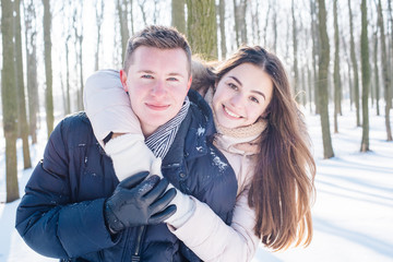 young loving couple having fun in snowy park
